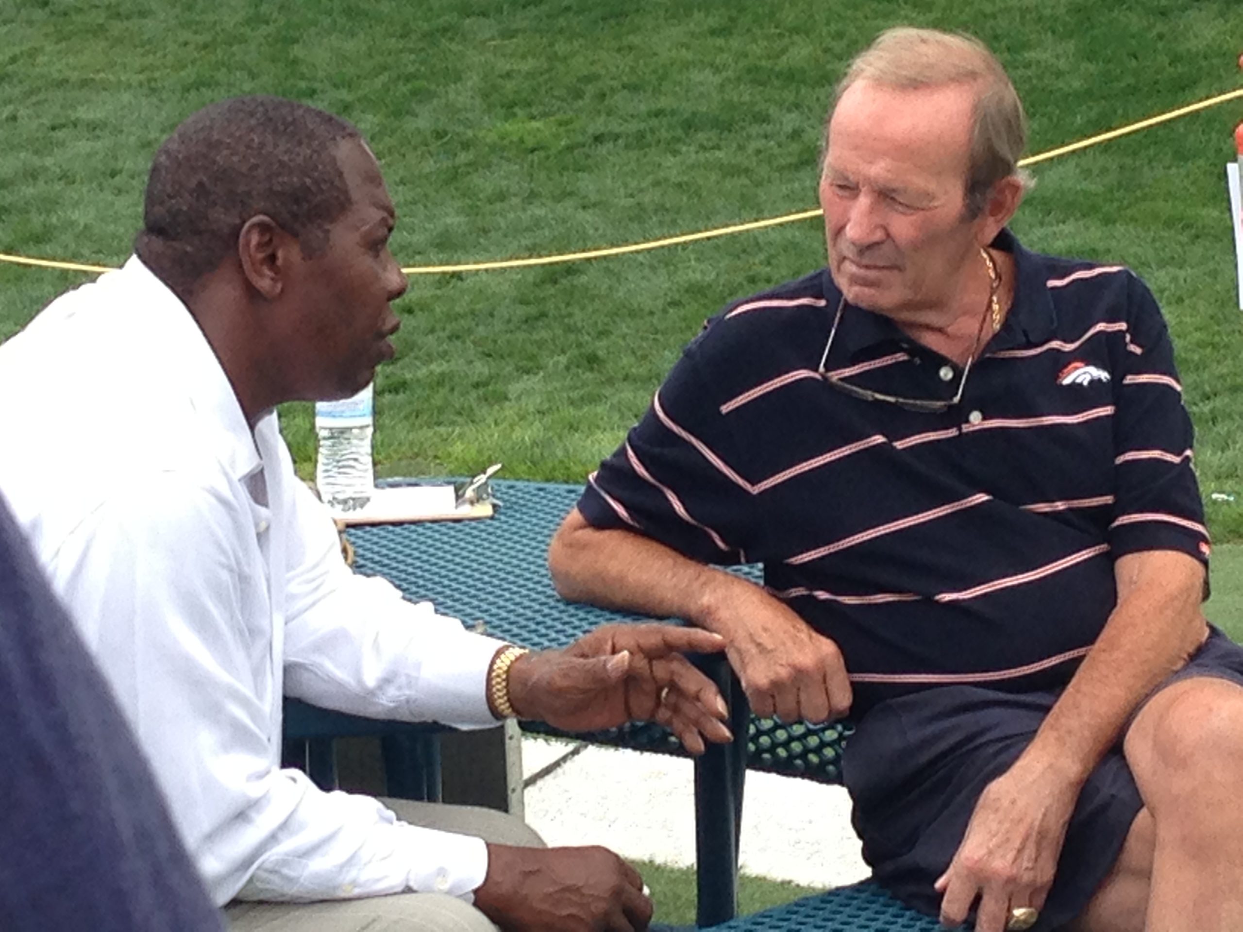 Professional athlete speaking with Denver Broncos owner Pat Bowlen during a production shoot